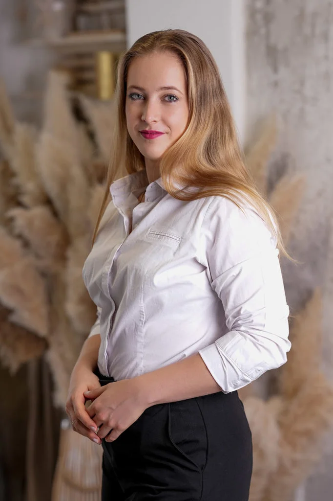 Üzleti fotózás enteriőr stúdióban áll egy fiatal elegáns nő