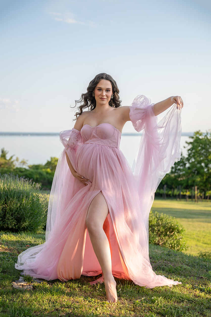 Kismama rózsaszín tüllruhában a Balaton partján, elegáns szabadtéri várandós fotózáson.